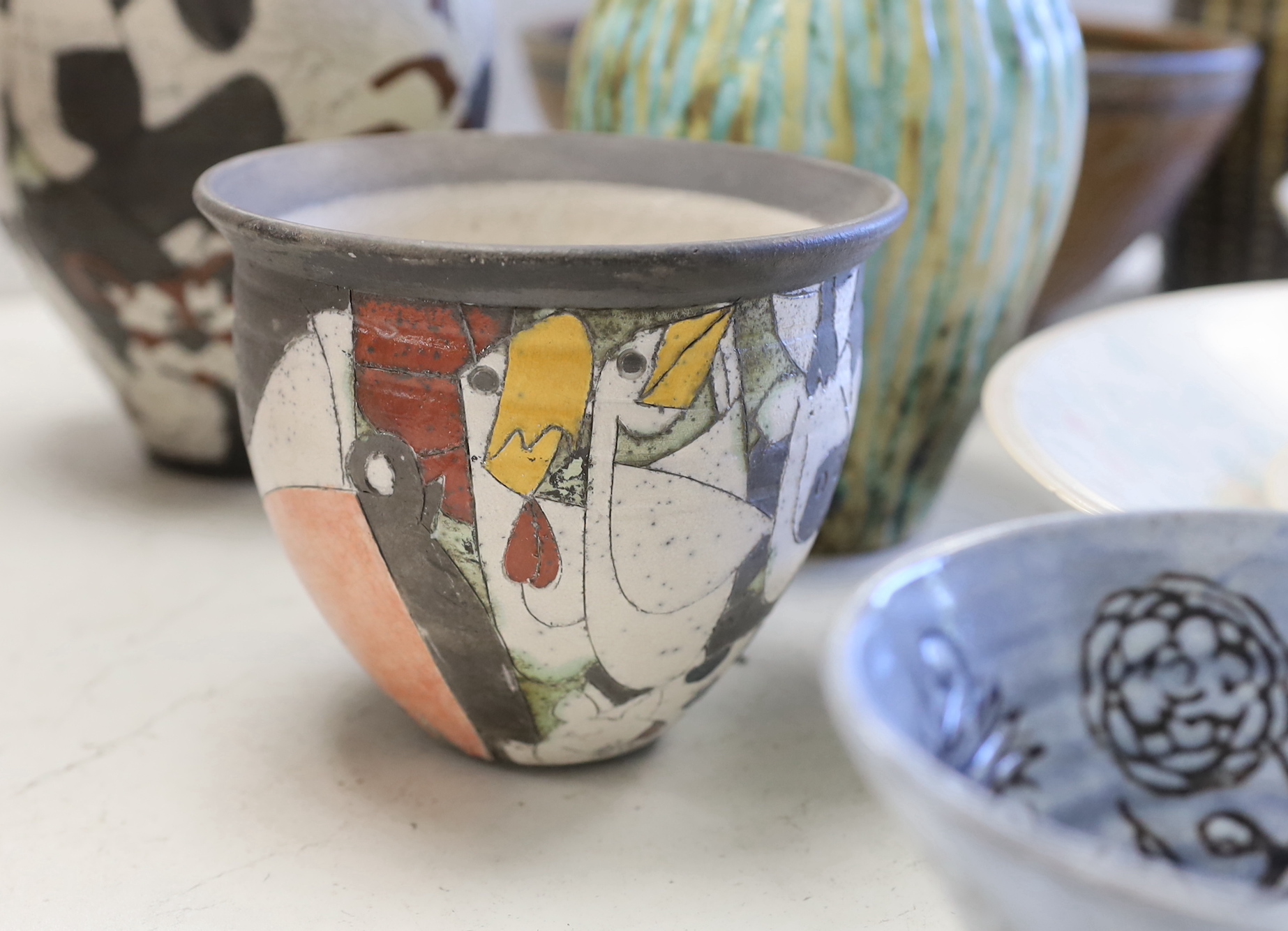 A collection of studio pottery including a Kenneth Annat Bemersyde Scottish vase, two graduated bowls and a jardiniere incised with birds, the largest 28cm high